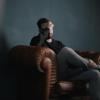Man sitting in couch holding head