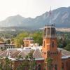 Aerial view of old main on a misty morning in spring with the flatirons in the background.