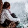Photo of a solemn girl sitting in Chautauqua Park looking out over the snowy mountains.