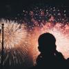 Silhouette of a man standing in front of a firework display.