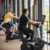 Two students riding stationary bikes on the top floor of the Rec Center.