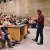 Photo of a faculty member giving a lecture to an auditorium full of students.