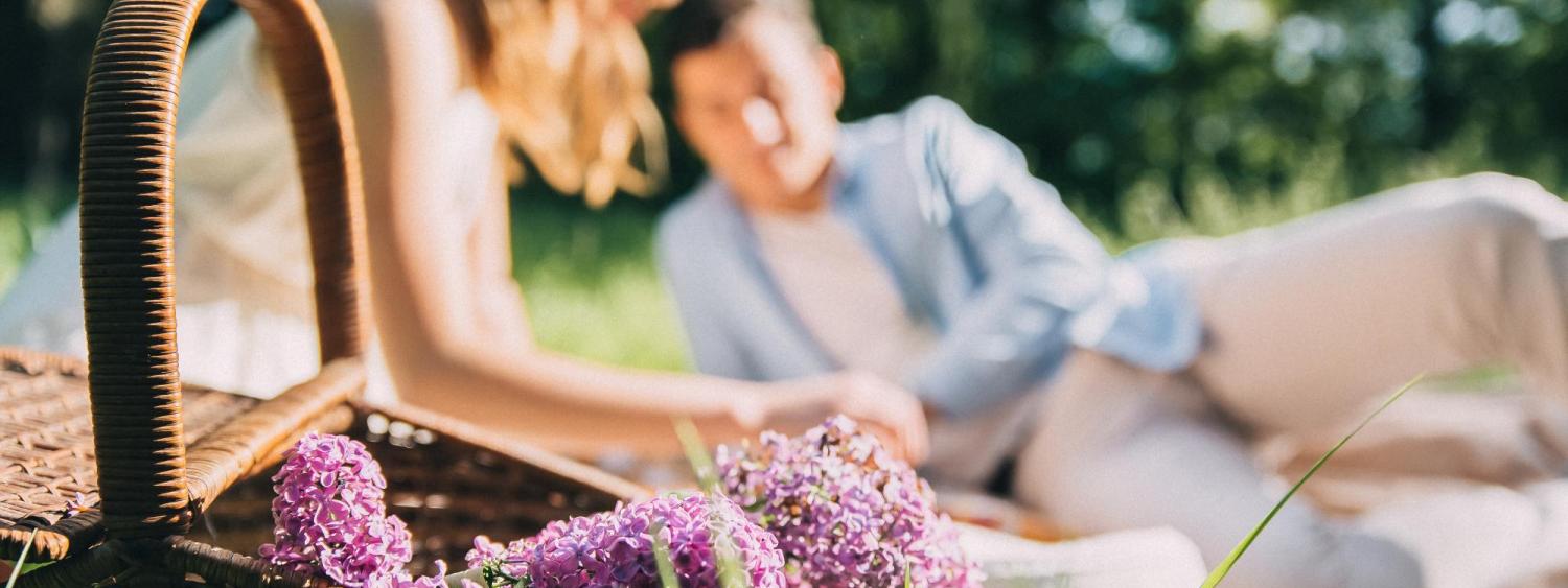 Photo of a couple enjoying a picnic with flowers.