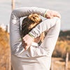 Girl stretching her arms during a run outside