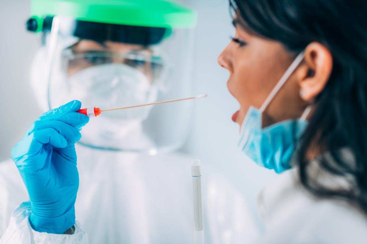 woman about to be swabbed by a doctor