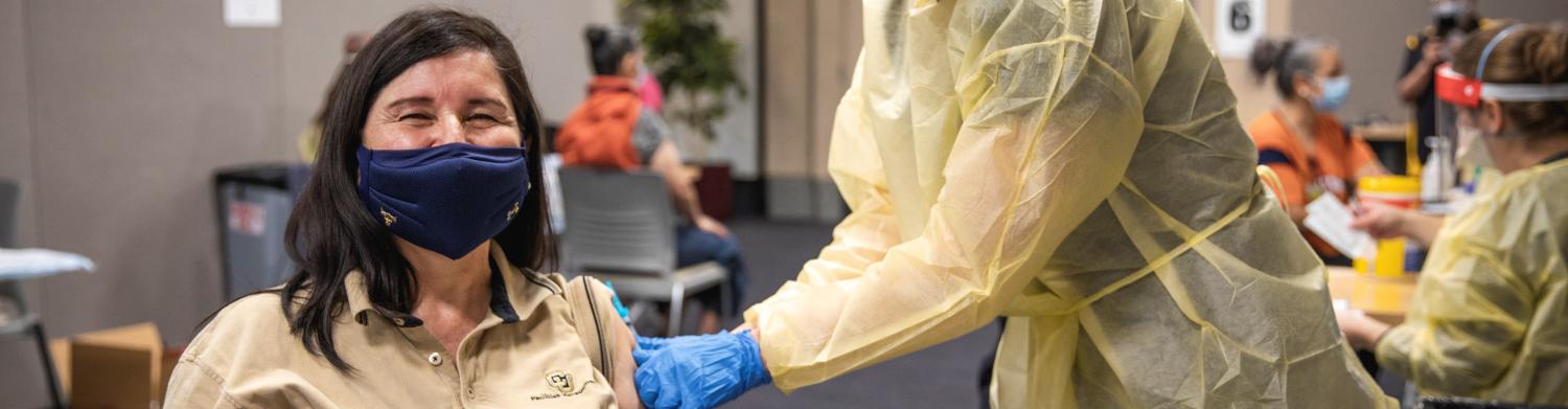 woman smiling as she gets a vaccine