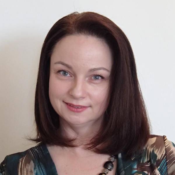 smiling woman with brown hair and a fancy shirt