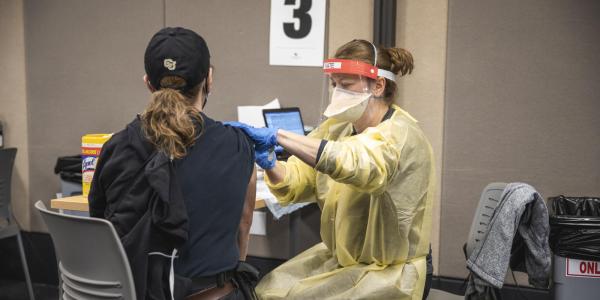 student in a cu hat getting a shot