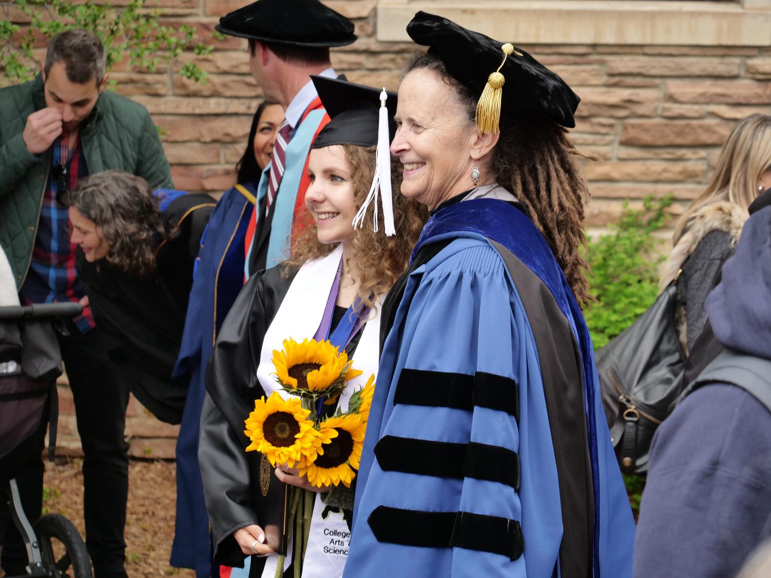 Student and professor having their photo taken at graduation