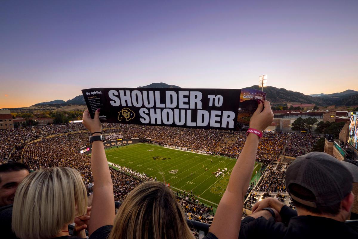 A CU fan holding a sign at the football game