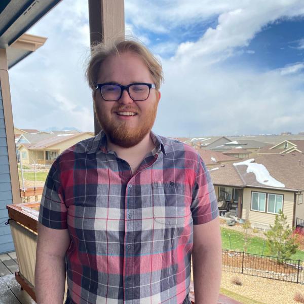 Austin Adams stands in front of a house.