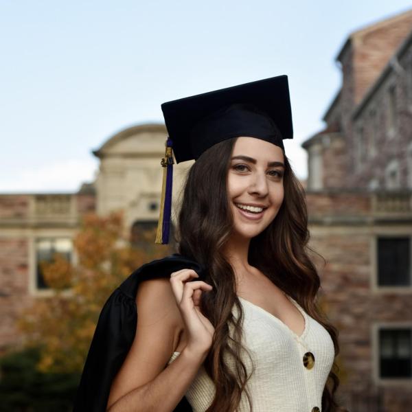 Alana Horwitz wears mortarboard and carries graduation gown