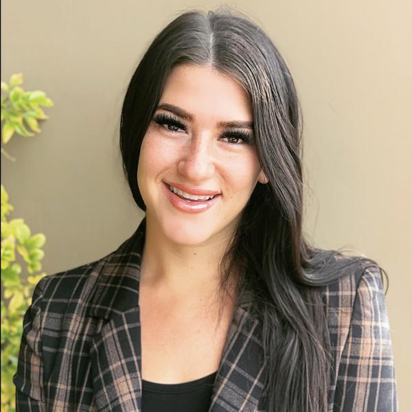 Aubrie Nicole Bailie smiling wearing a plaid jacket
