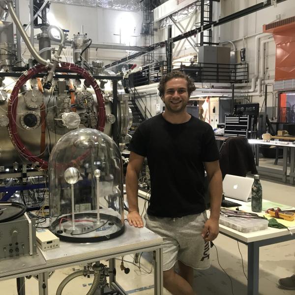 Ethman Ayari stands next to equipment in a lab. 