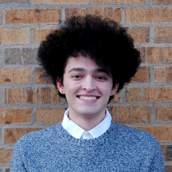 Ferris Bosworth stands in front of a brick wall. 