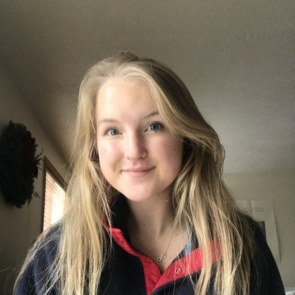 Brooke Kennedy smiles, wearing a multi-colored shirt