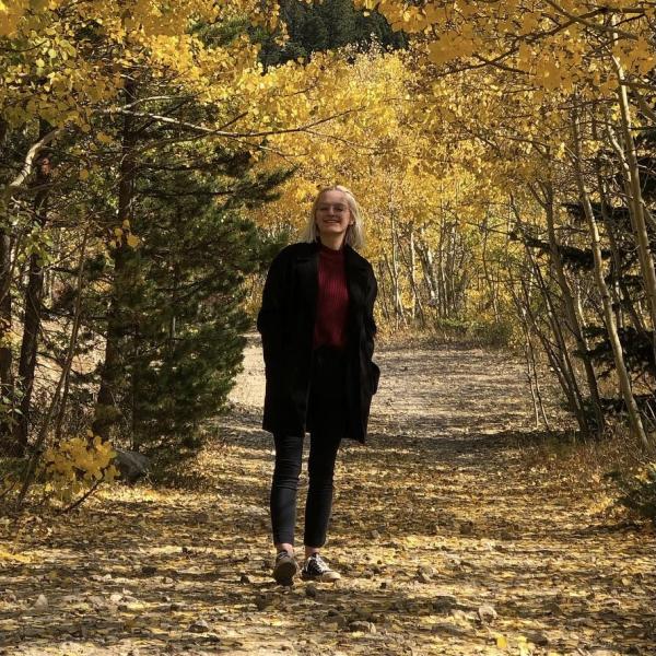 Olivia Bulik standing in between trees. 