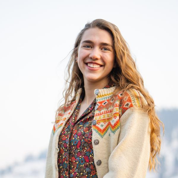 Nyika Campbell stands in front of a mountain.