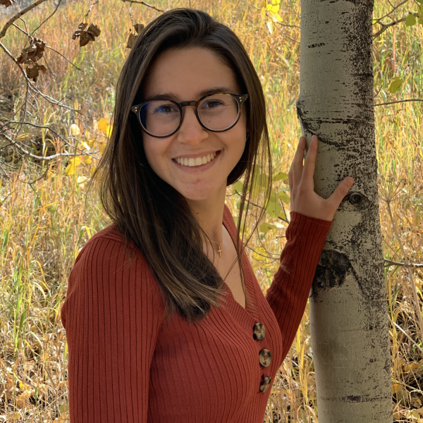 Maria Carilli stands next to a tree.