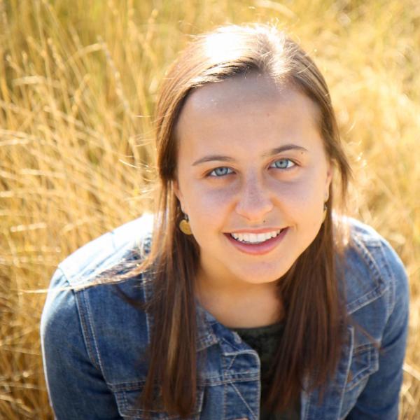 Alia Clark-ElSayed sits on a field of grain. 