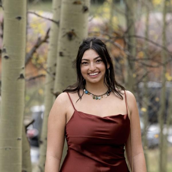 Anna Cohen stands in front of trees.