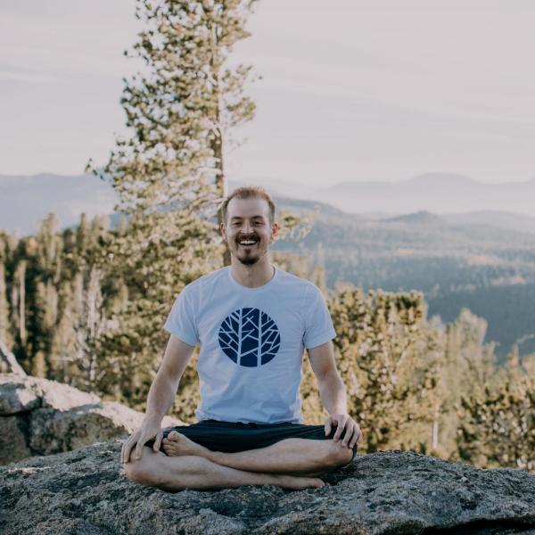 Christopher Corlett sits on a rock. 