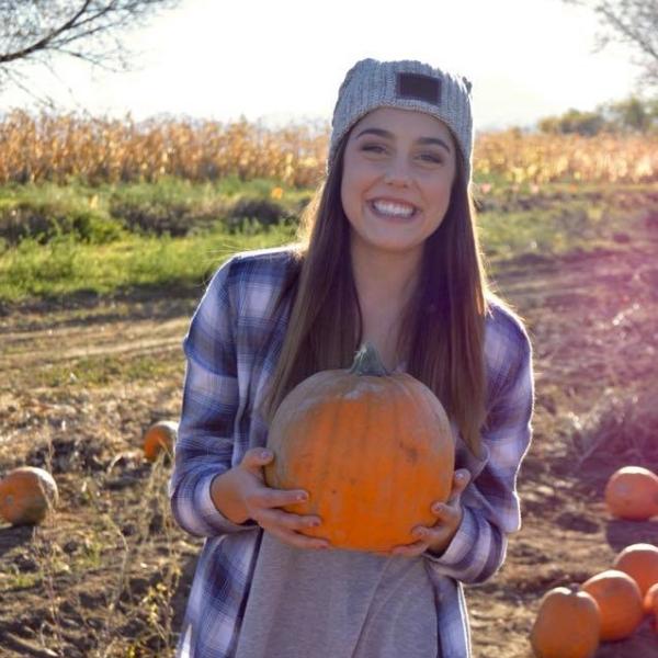 Dakota Kisling holding pumpkin in pumpkin patch