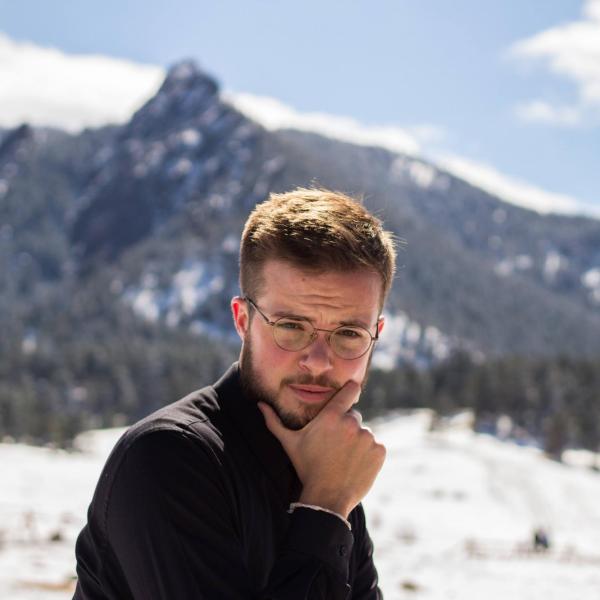 Jake Drewes stands in front of a mountain.