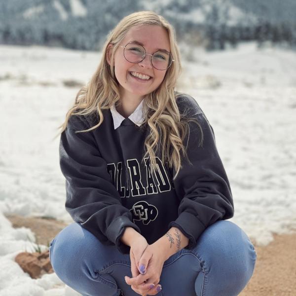 Anna Estes sitting in front of a mountain.