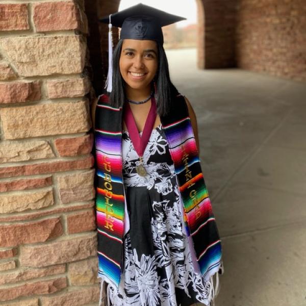 Mariana Galvez Seminario stands next to brick column.