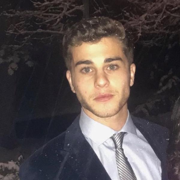 Adam Garfinkel stands in front of snowy tree.