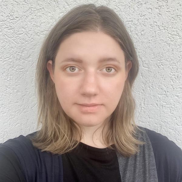 Arina Gorokhovska stands in front of wall.