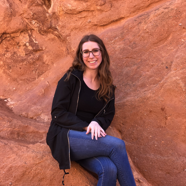 Katelynn Hughes sits on a rock.
