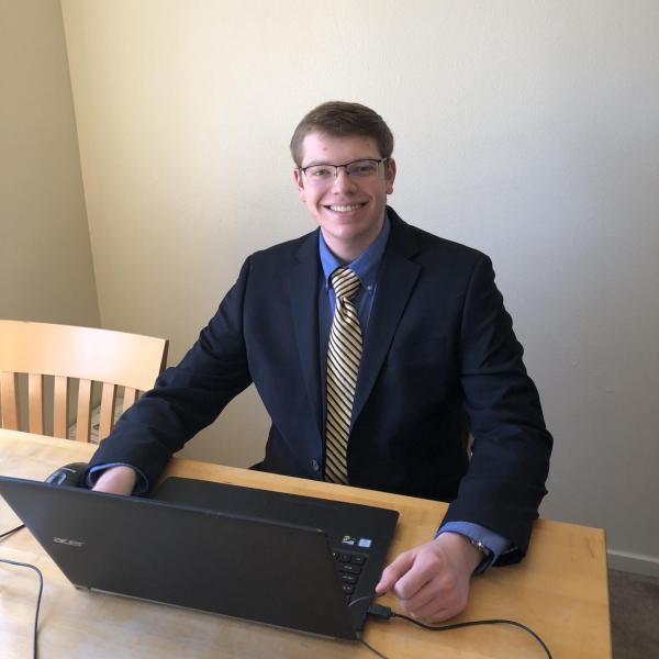 Benjamin Humphries sits at a table in front of his laptop.