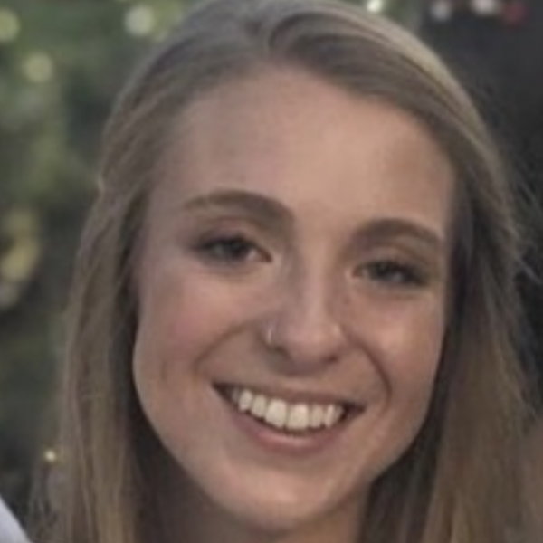 Julia Schmidt wears a white shirt and smiles for the camera