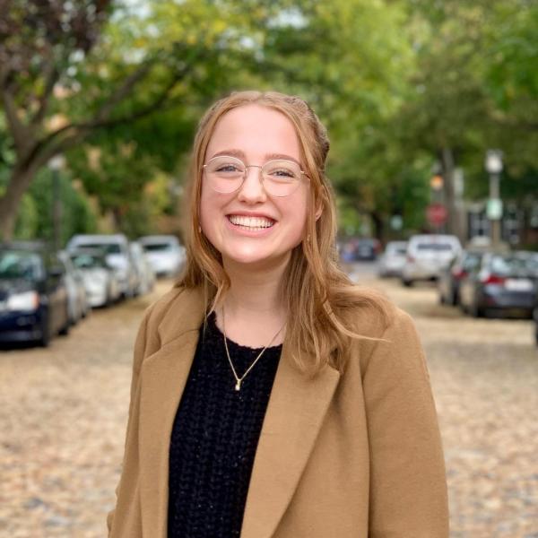 Julianna Rohn standing in leaf covered street with cars and trees in the background