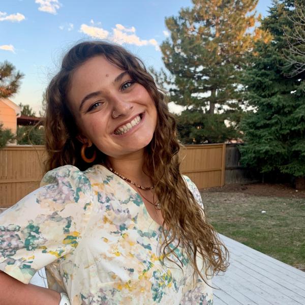 Gabrielle Knopp stands in front of a fence.
