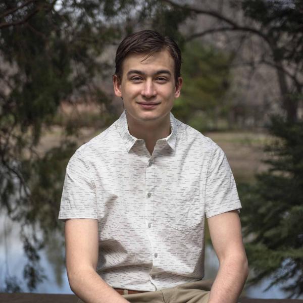 Trevor Koglin sits in front of a lake.