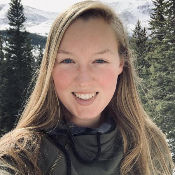 Madison Kunkel stands in front of trees.
