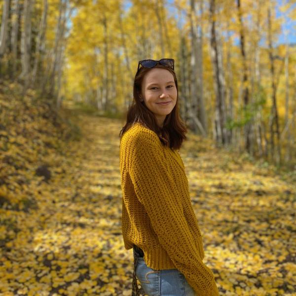 Michelle Leach stands in front of trees.