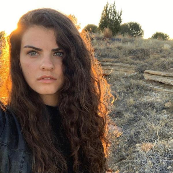 Anastasia Mathews stands in front of an open field. 