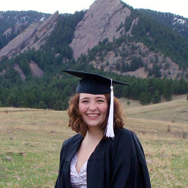 Jade Munsinger stands in front of a mountain.