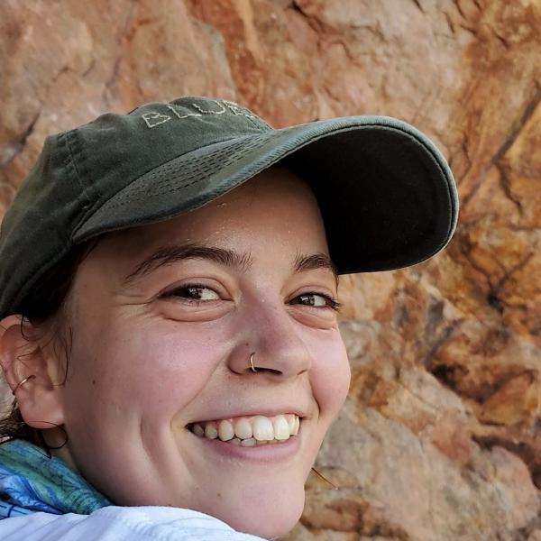 Lisa Muschinski sits next to a rock.