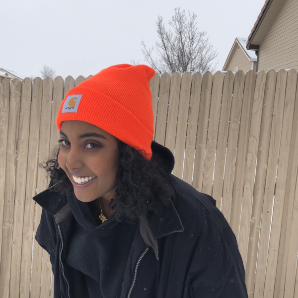 Marwa Osman stands in front of a fence.