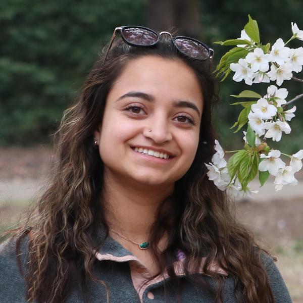 Ruja Parikh stands in front of trees.