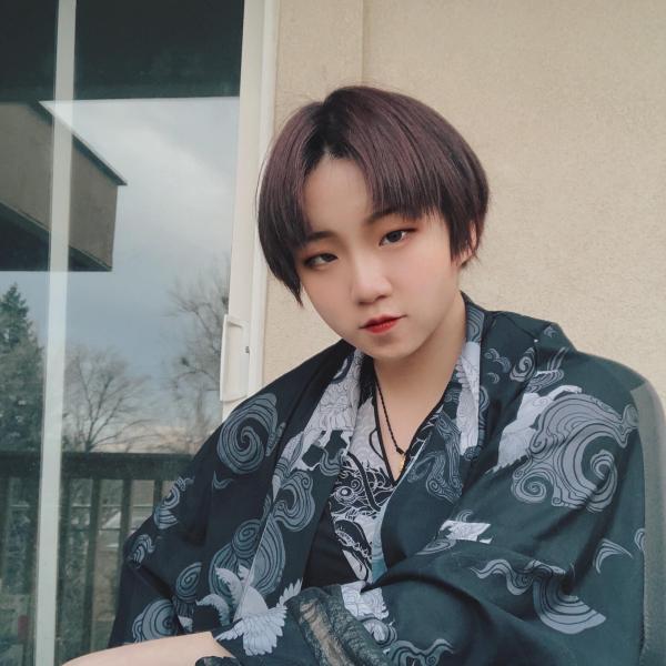Wei Qu sits in front of a window.