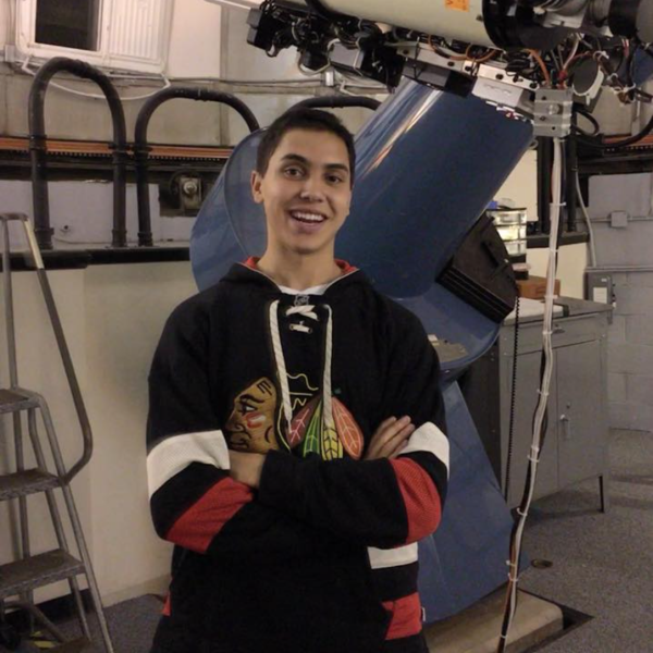 Alexander Rodriguez stands next to equipment in a lab.