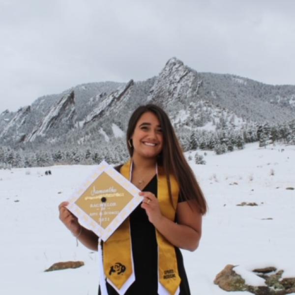 Sami Guneratne standing in snow in front of the Boulder flatirons