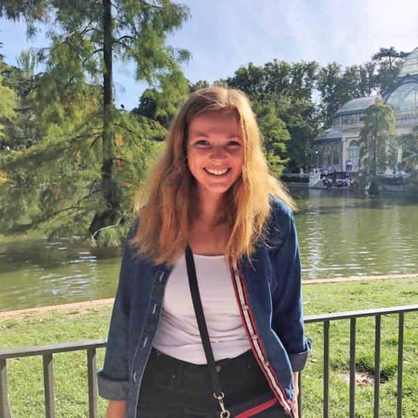 Emma Scheetz stands in front of a lake.