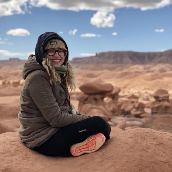 Sarah Schleifer sits on top of a rock.